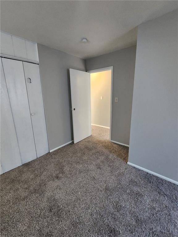 unfurnished bedroom featuring carpet flooring and a closet