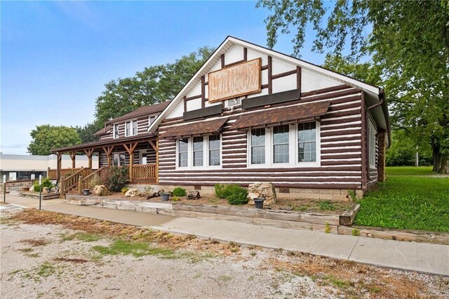 121 W US Highway 40, Odessa, MO 64076 - view of front facade with log siding and crawl space
