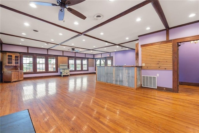 unfurnished living room with beam ceiling, light wood-type flooring, a wealth of natural light, and ceiling fan