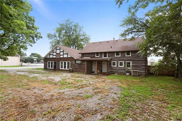 back of house with a yard and central AC