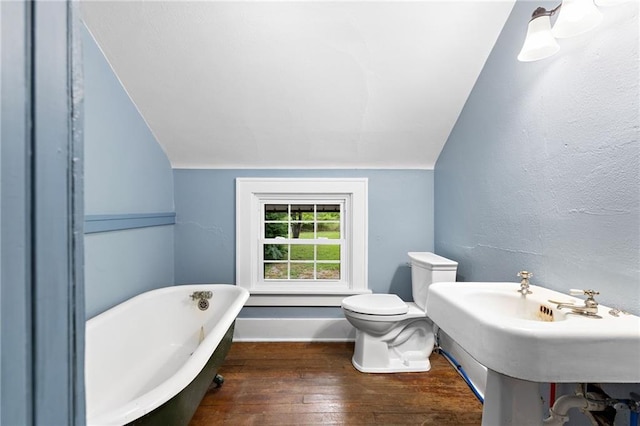 bathroom featuring a tub to relax in, toilet, lofted ceiling, and hardwood / wood-style flooring