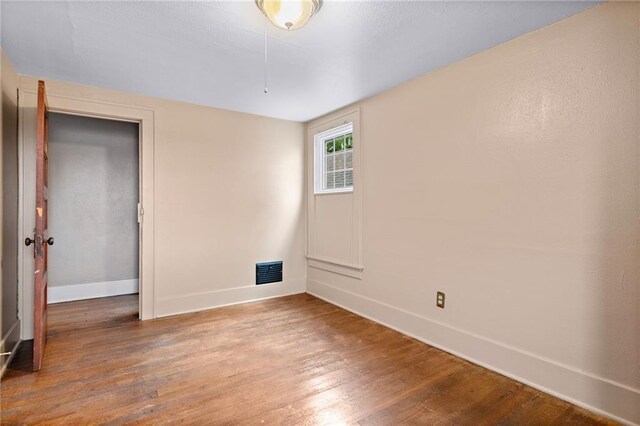 unfurnished room with hardwood / wood-style floors