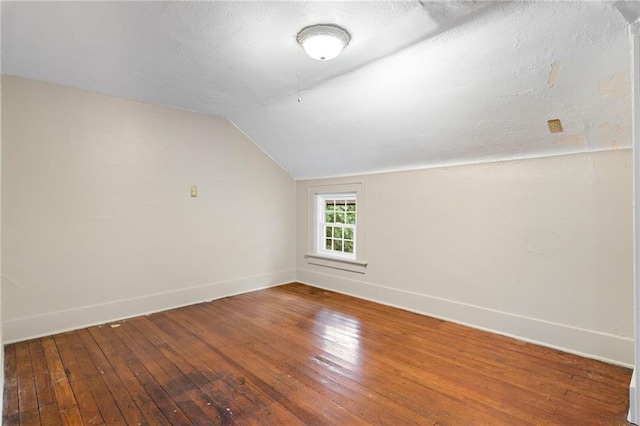 bonus room featuring a textured ceiling, hardwood / wood-style flooring, and vaulted ceiling