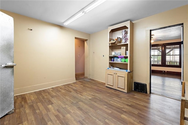 unfurnished room with ceiling fan and dark wood-type flooring