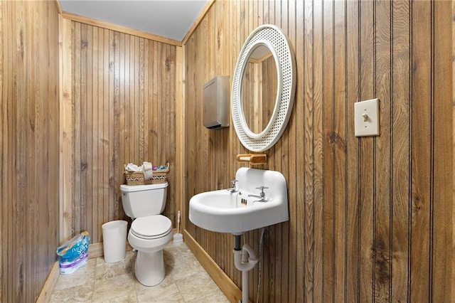 bathroom with wood walls and toilet