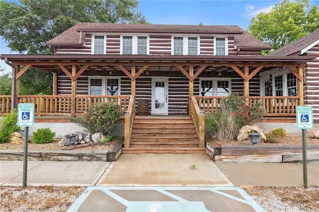 121 W US Highway 40, Odessa, MO 64076 - view of front of home with covered porch, log siding, and roof with shingles