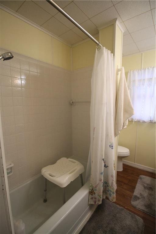 bathroom featuring hardwood / wood-style flooring and shower / bathtub combination with curtain