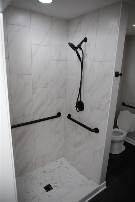 bathroom with tiled shower and toilet