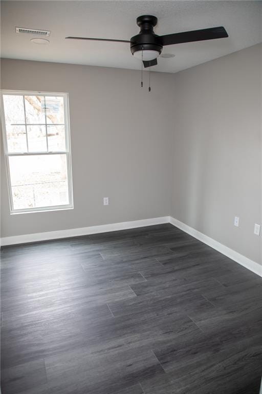 spare room with ceiling fan and dark hardwood / wood-style flooring