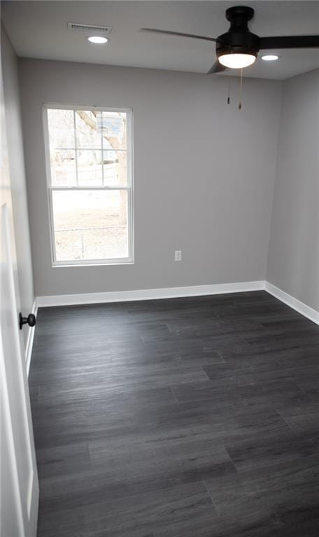 spare room with dark wood-type flooring and ceiling fan