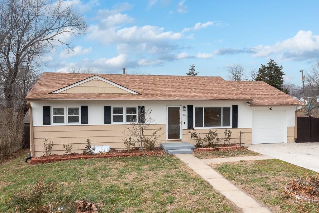 ranch-style house with a garage and a front yard