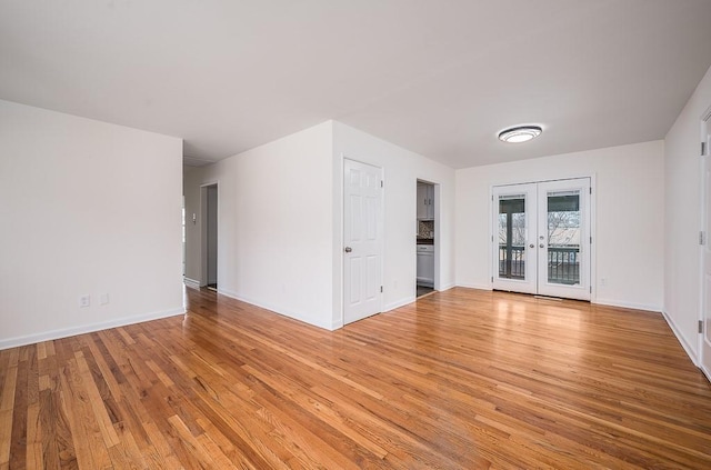 empty room with french doors and light hardwood / wood-style floors