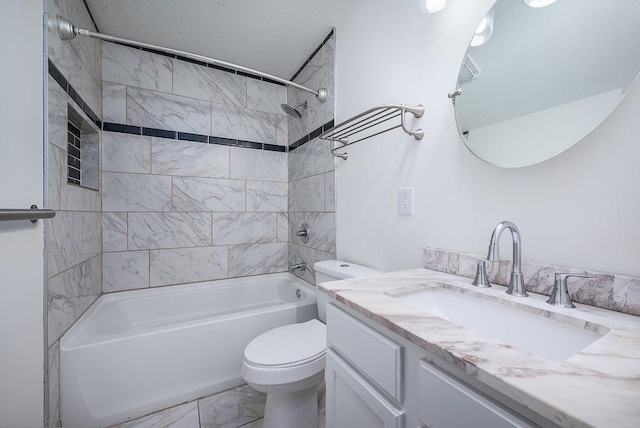 full bathroom featuring tiled shower / bath, vanity, and toilet