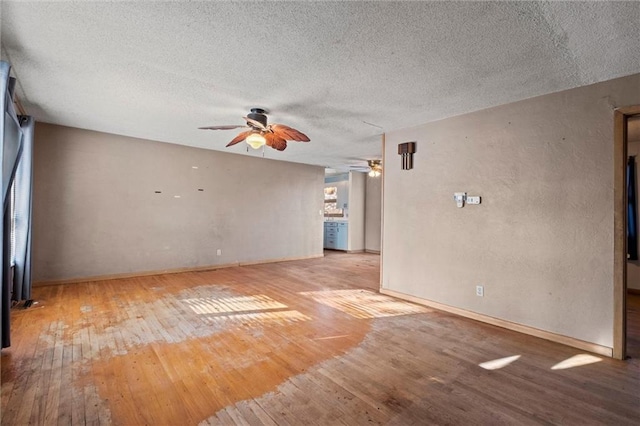 empty room with light wood-type flooring and a textured ceiling