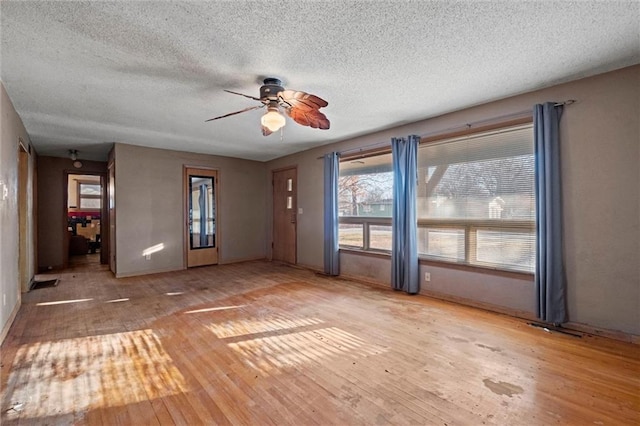 unfurnished room with ceiling fan, light hardwood / wood-style floors, and a textured ceiling