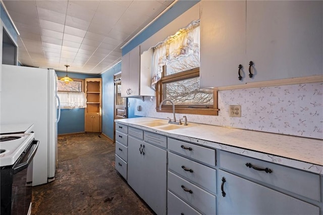 kitchen featuring white range with electric cooktop, sink, and hanging light fixtures