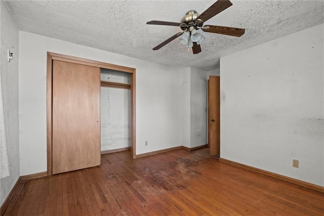 unfurnished bedroom featuring a closet, ceiling fan, hardwood / wood-style floors, and a textured ceiling