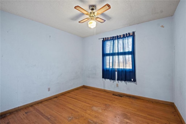 spare room featuring ceiling fan, wood-type flooring, and a textured ceiling