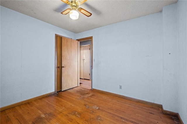 spare room with ceiling fan, a textured ceiling, and light hardwood / wood-style flooring