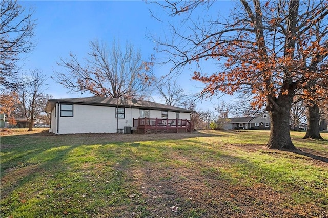 back of house featuring a lawn and a wooden deck