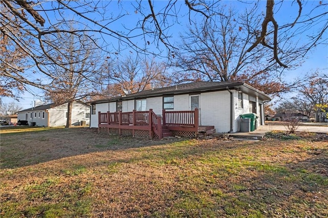 rear view of property with a lawn and a wooden deck