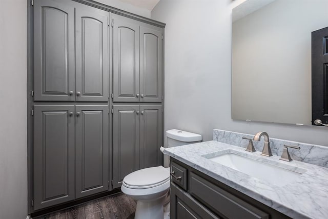 bathroom featuring toilet, vanity, and hardwood / wood-style flooring