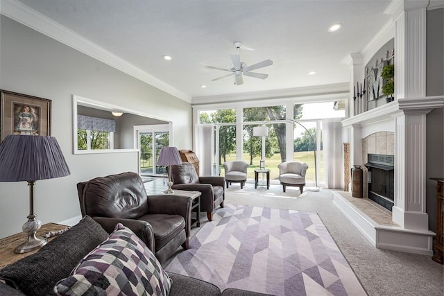 living room with a tile fireplace, light carpet, ceiling fan, and ornamental molding