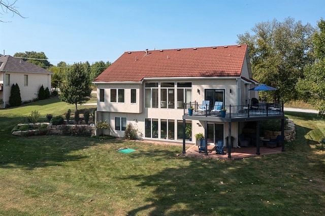 back of property with a patio and a lawn