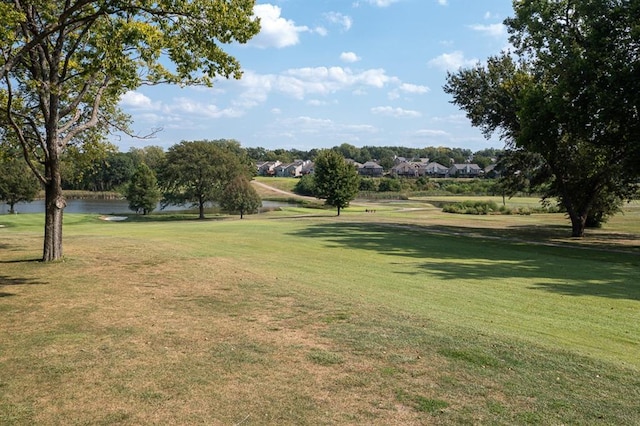 view of home's community featuring a lawn and a water view