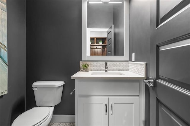 bathroom featuring vanity, toilet, and tasteful backsplash