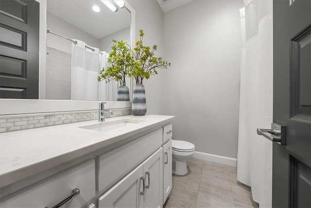 bathroom featuring tile patterned flooring, vanity, tasteful backsplash, and toilet