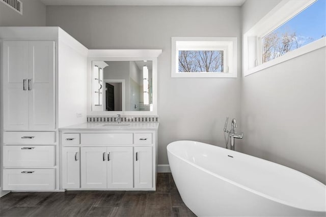 bathroom featuring vanity, a tub to relax in, and hardwood / wood-style flooring