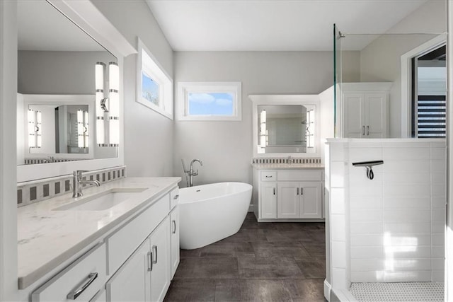 1106 Saxony Ct, Warrensburg, MO 64093 - bathroom with two vanities, a freestanding tub, and tiled shower
