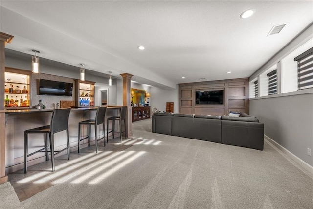 carpeted living room featuring bar area