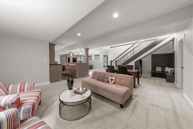 carpeted living room featuring decorative columns