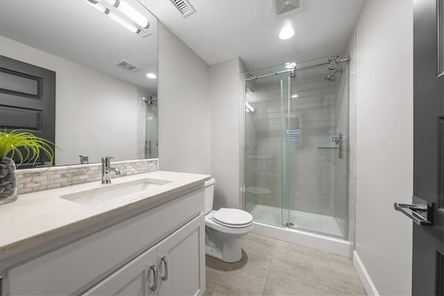 bathroom featuring vanity, tile patterned floors, toilet, tasteful backsplash, and a shower with shower door