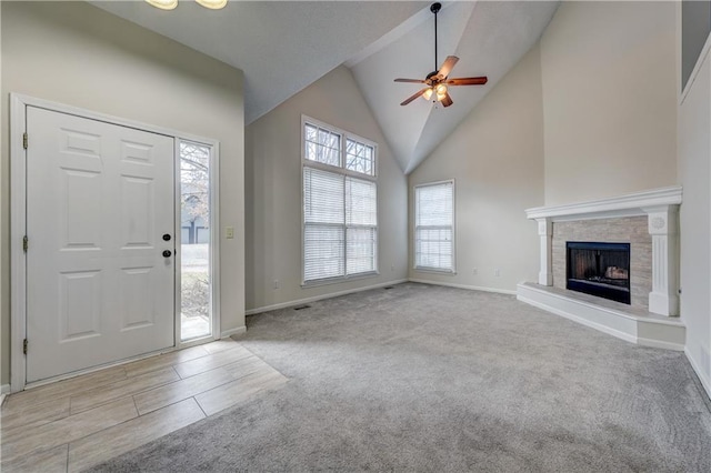 carpeted foyer entrance featuring ceiling fan and high vaulted ceiling