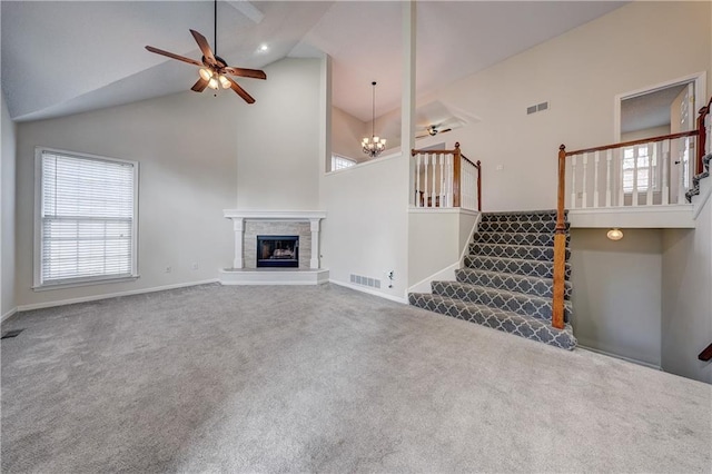 unfurnished living room featuring a tile fireplace, carpet, ceiling fan with notable chandelier, and high vaulted ceiling