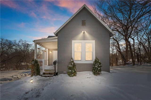 snow covered property with a porch