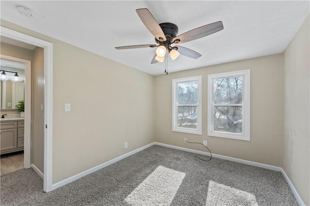 carpeted spare room featuring ceiling fan