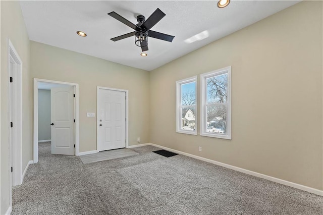 carpeted spare room featuring ceiling fan