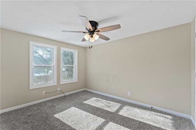 unfurnished room with carpet flooring, baseboards, and a ceiling fan