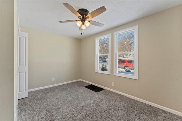 carpeted empty room featuring a textured ceiling, baseboards, and ceiling fan