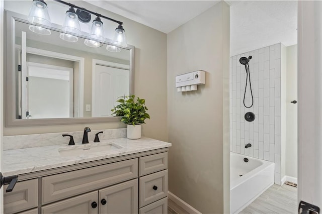 full bath with washtub / shower combination, baseboards, wood finished floors, and vanity