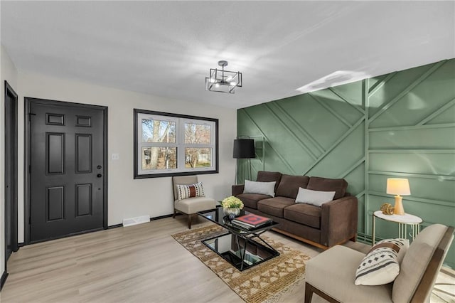 living room featuring an inviting chandelier and light hardwood / wood-style flooring