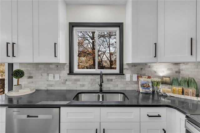 kitchen with stainless steel appliances, white cabinetry, tasteful backsplash, and sink