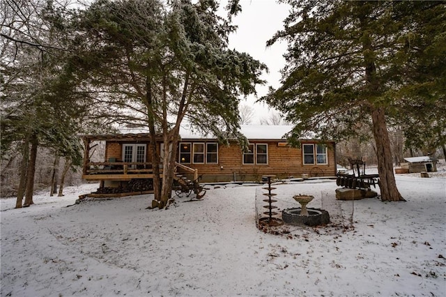 snow covered house with a wooden deck