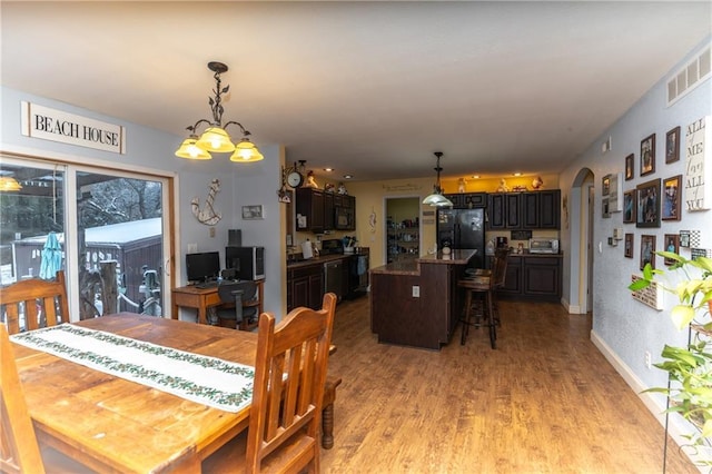 dining area with light hardwood / wood-style flooring and an inviting chandelier