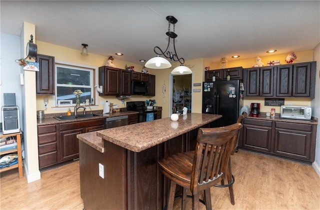 kitchen with black appliances, dark brown cabinets, pendant lighting, and sink