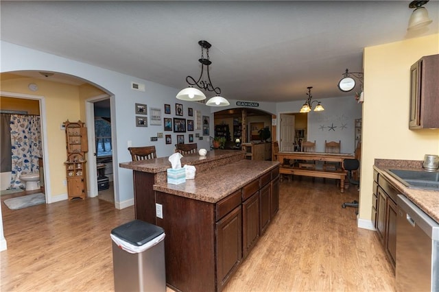 kitchen featuring dishwasher, dark brown cabinets, decorative light fixtures, and a chandelier